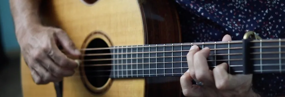 Close up of two hands playing the guitar