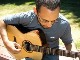 Anton sitting outside in the sun with his Alberico guitar